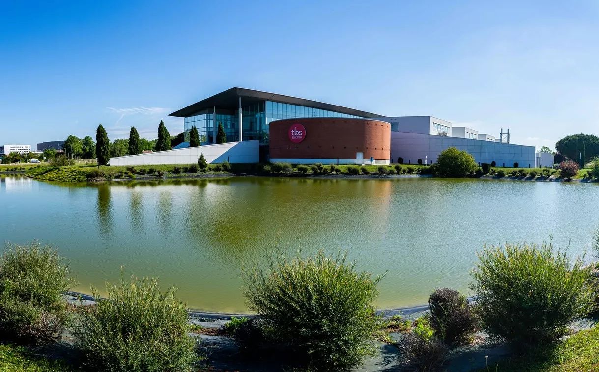 Vue attrayante du campus CPA de Toulouse, avec un plan d'eau au premier plan.