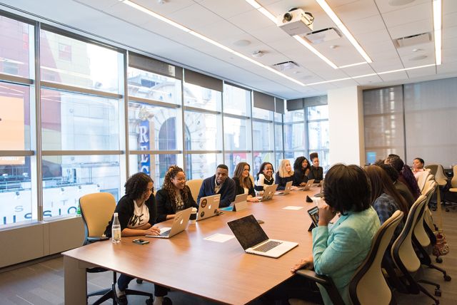 Photographie d'une assemblée de personnes avec des ordinateurs portables posés devant eux, symbolisant le réseau des alumni CPA.