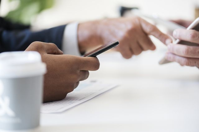 Photographie de mains qui manipulent des téléphones portables, pour symboliser la notion de réseau des alumni CPA.